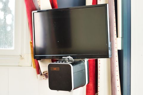 A budget LCD TV with a budget bluetooth speaker strapped to the bottom of it.