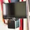 A budget LCD TV with a budget bluetooth speaker strapped to the bottom of it.